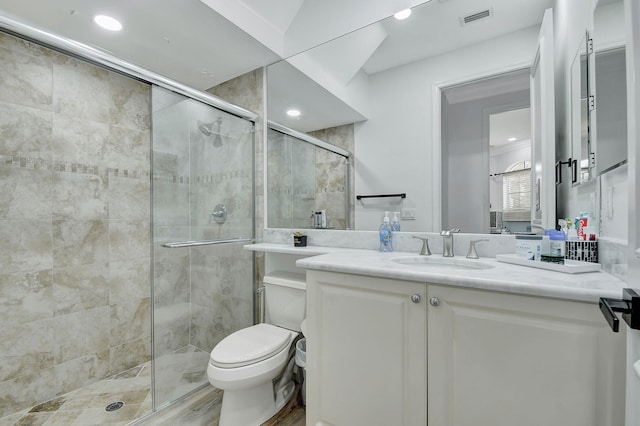 bathroom featuring a shower with door, toilet, and vanity