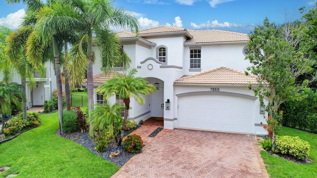 mediterranean / spanish-style house with a garage and a front lawn