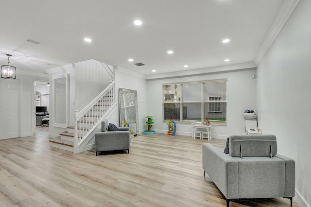 living room with light hardwood / wood-style floors, a chandelier, and crown molding