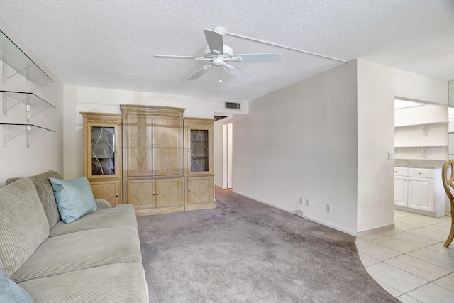 unfurnished living room with ceiling fan, light colored carpet, and a textured ceiling