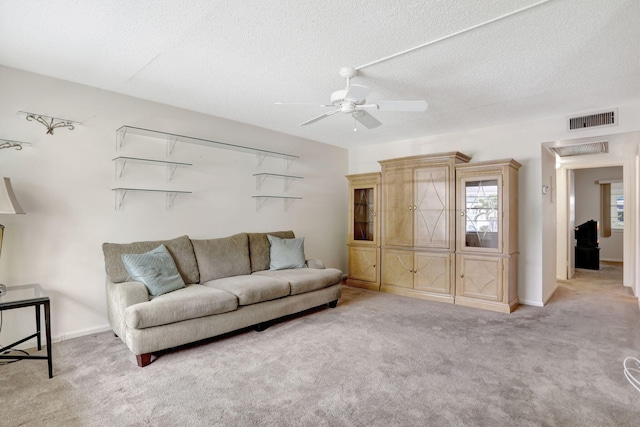 carpeted living room with a textured ceiling and ceiling fan