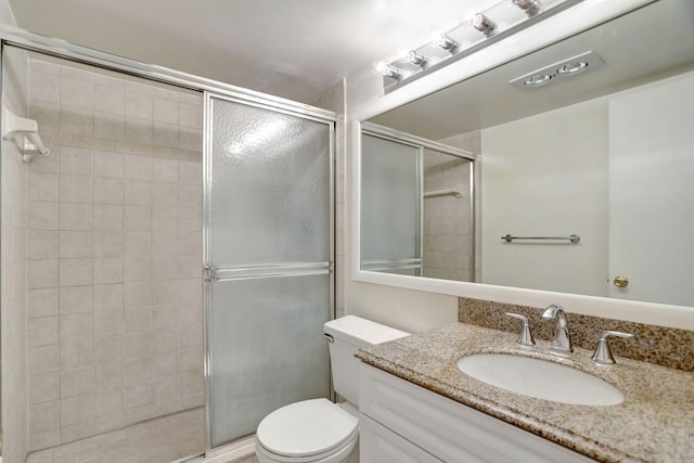 bathroom with vanity, toilet, and an enclosed shower