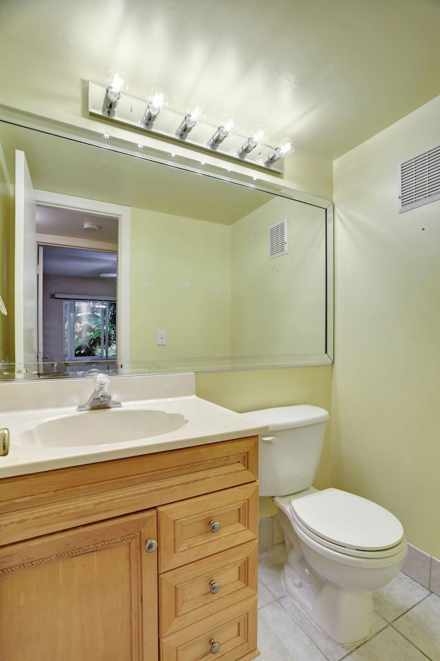 bathroom featuring tile patterned flooring, vanity, and toilet