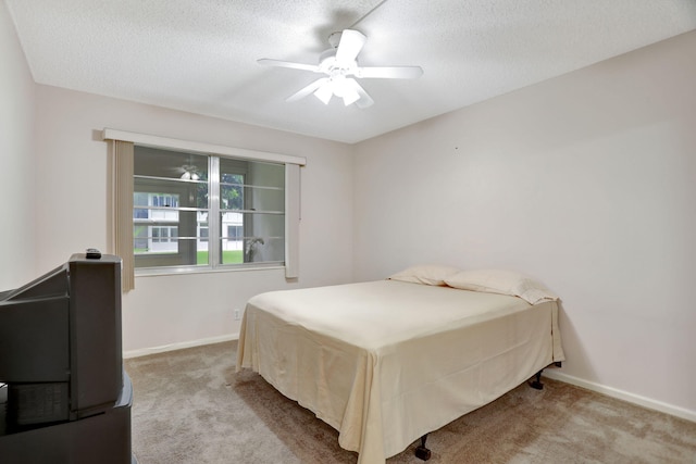 bedroom featuring ceiling fan, a textured ceiling, and light carpet