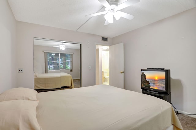 carpeted bedroom featuring a closet, ceiling fan, and a textured ceiling