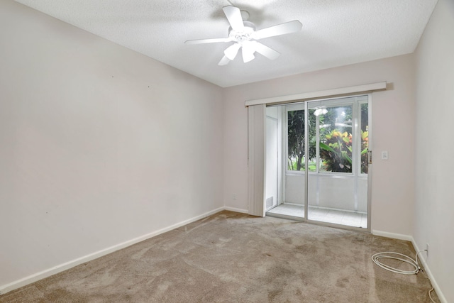 carpeted empty room featuring ceiling fan and a textured ceiling