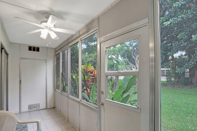 unfurnished sunroom with ceiling fan