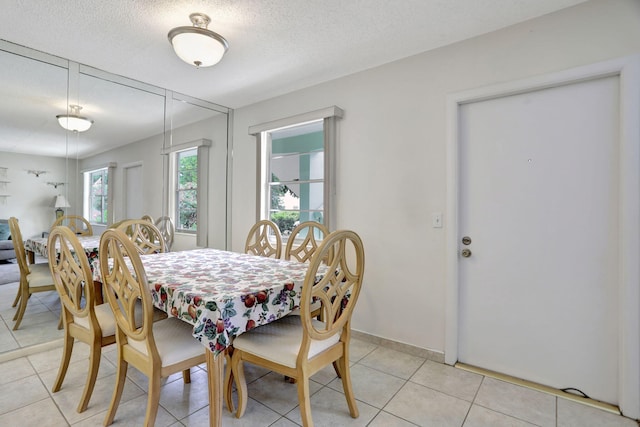 dining room with a textured ceiling and light tile patterned floors