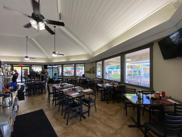 tiled dining space featuring ceiling fan and lofted ceiling with beams