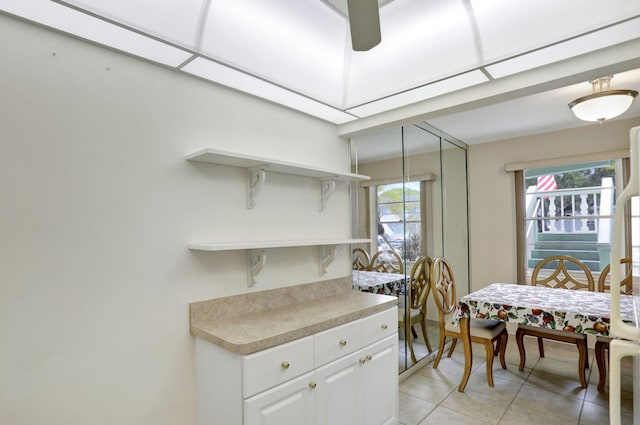 kitchen with light tile patterned floors and white cabinetry