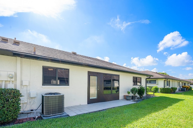 back of house with a yard and central AC unit