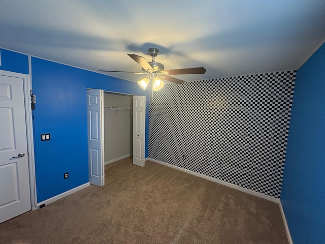 unfurnished bedroom with ceiling fan, carpet flooring, and a closet