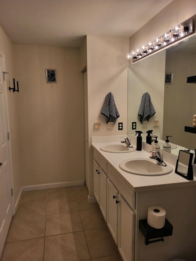 bathroom with vanity, a textured ceiling, and tile patterned flooring