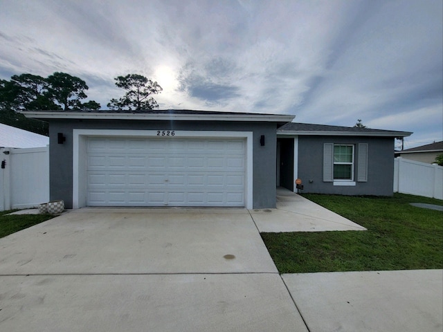 single story home featuring a front lawn and a garage