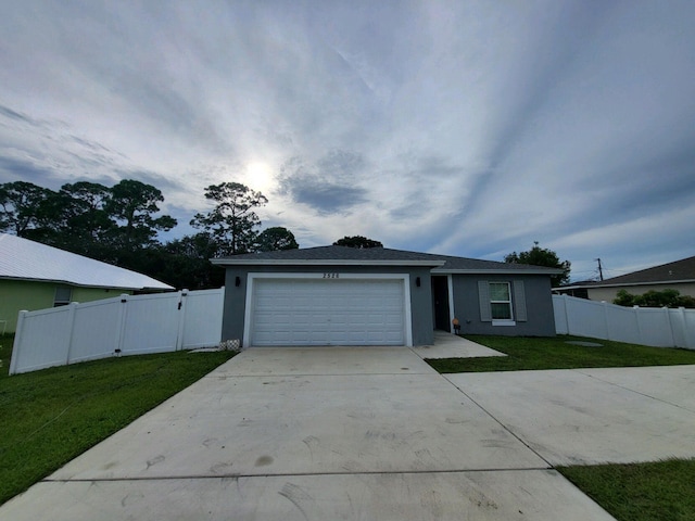 ranch-style house featuring a garage and a front lawn