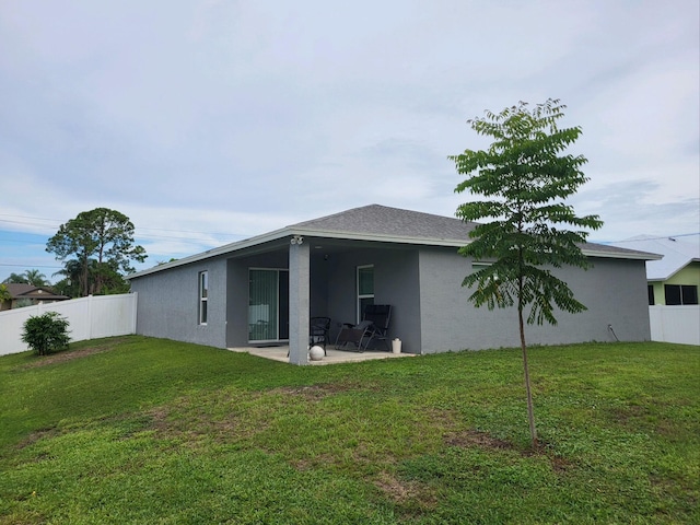 back of house with a yard and a patio area