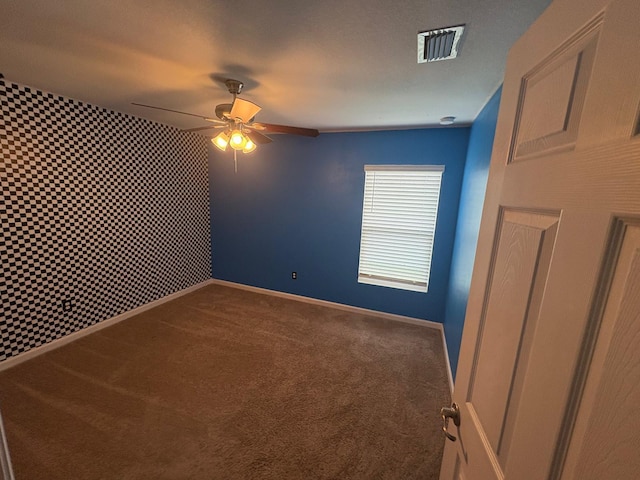 carpeted empty room featuring ceiling fan and a textured ceiling