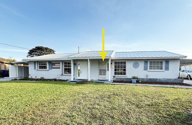 single story home with metal roof, a carport, and a front yard