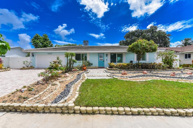 ranch-style home featuring a garage and a front lawn