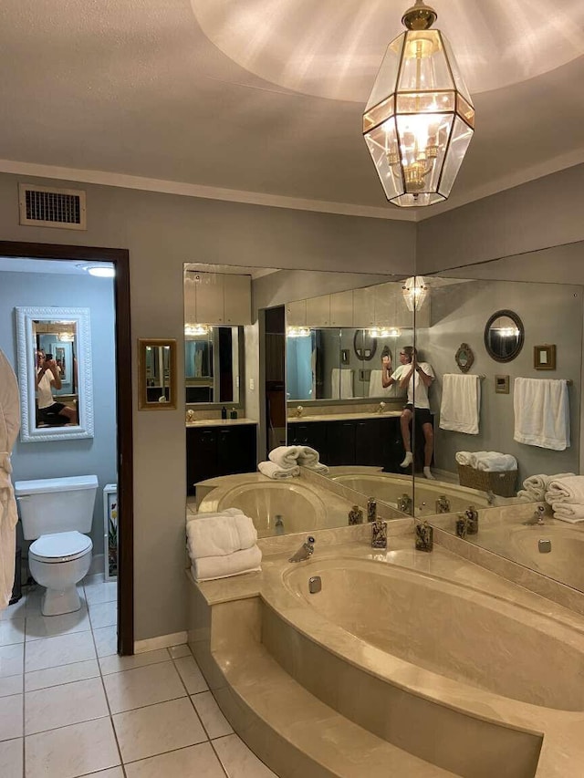 bathroom with toilet, tile patterned flooring, vanity, crown molding, and a bath