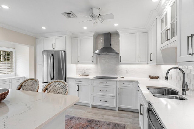 kitchen with sink, appliances with stainless steel finishes, wall chimney range hood, and tasteful backsplash