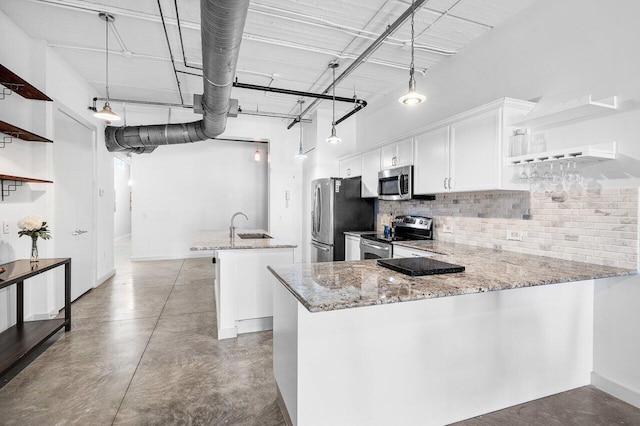 kitchen with white cabinets, appliances with stainless steel finishes, pendant lighting, and kitchen peninsula