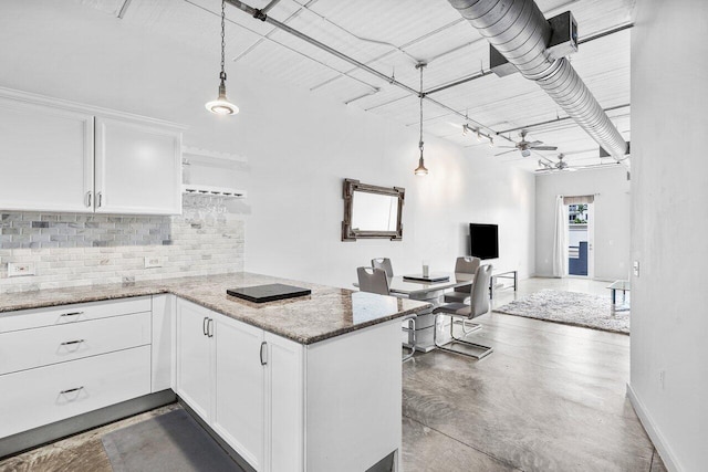 kitchen with kitchen peninsula, decorative light fixtures, and white cabinets