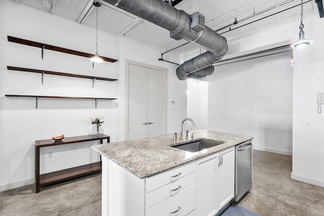 kitchen with light stone counters, decorative light fixtures, sink, and white cabinets