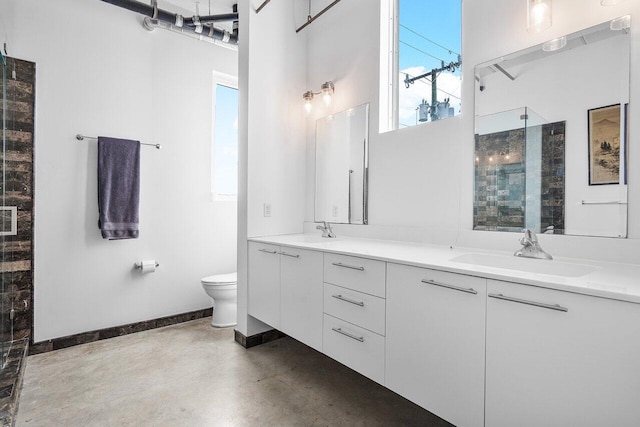 bathroom with concrete floors, vanity, toilet, and an enclosed shower