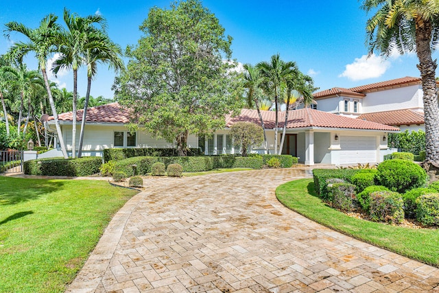 mediterranean / spanish-style house featuring a front lawn and a garage