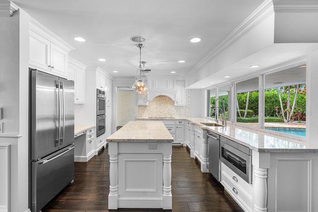 kitchen with pendant lighting, stainless steel appliances, dark hardwood / wood-style floors, and white cabinetry