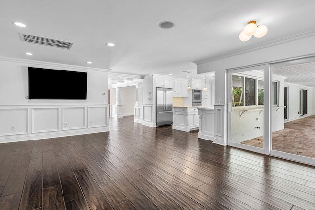 unfurnished living room featuring dark wood-type flooring and crown molding