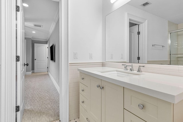 bathroom featuring vanity, crown molding, and an enclosed shower