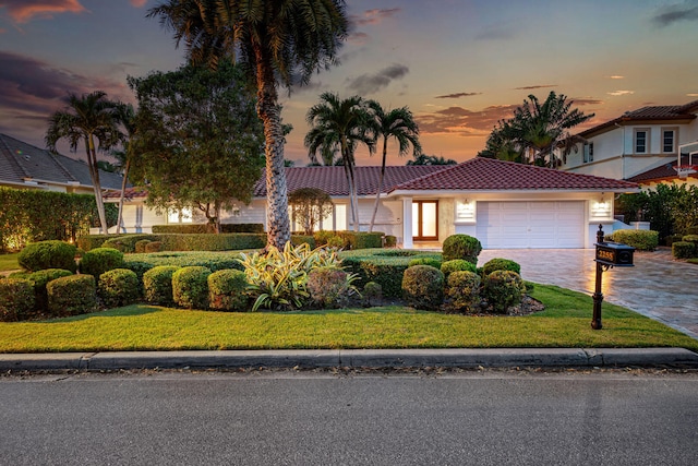 view of front of property with a yard and a garage