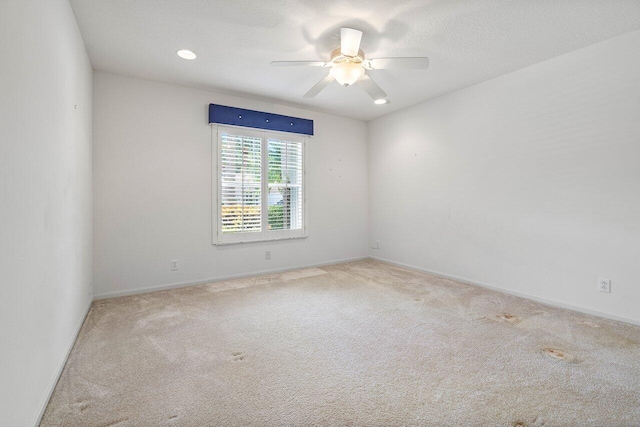 unfurnished room with ceiling fan and light colored carpet