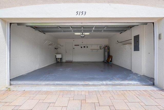 garage with sink, a garage door opener, water heater, and electric panel