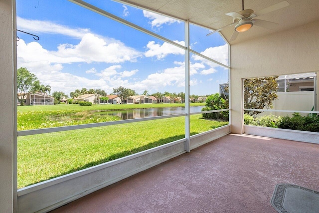 unfurnished sunroom featuring ceiling fan and a water view