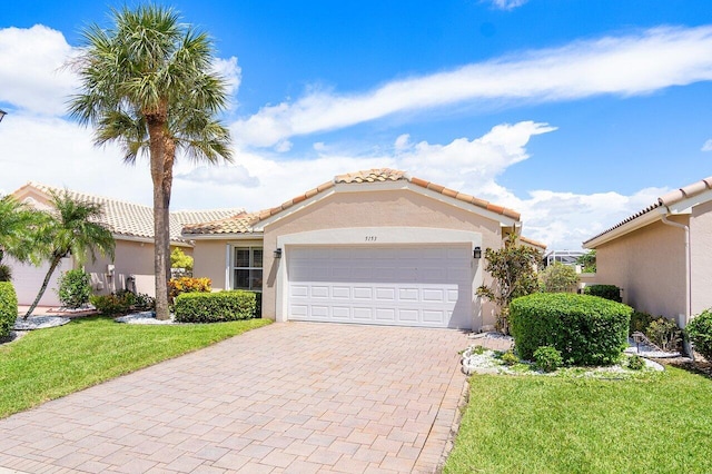 mediterranean / spanish house with a garage and a front yard