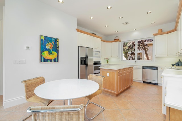 kitchen featuring light tile patterned floors, stainless steel appliances, light countertops, visible vents, and a kitchen island