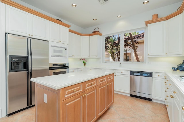 kitchen featuring light tile patterned floors, recessed lighting, stainless steel appliances, visible vents, and a center island