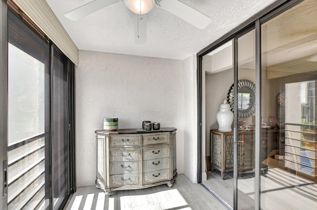 interior space with a textured ceiling, hardwood / wood-style flooring, and ceiling fan