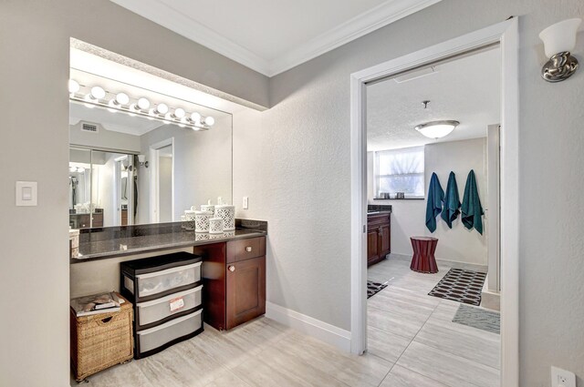 bathroom with crown molding, vanity, and tile patterned flooring