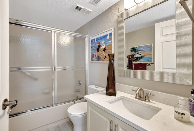 full bathroom with toilet, vanity, a textured ceiling, bath / shower combo with glass door, and hardwood / wood-style flooring