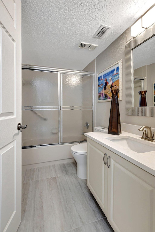 full bathroom with tile patterned flooring, toilet, enclosed tub / shower combo, and vanity