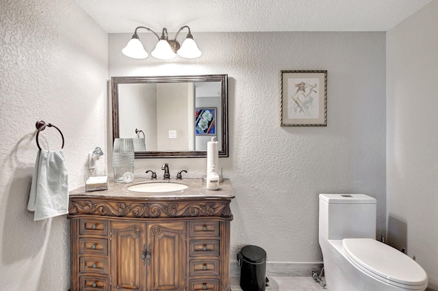 bathroom featuring vanity, toilet, and a textured ceiling