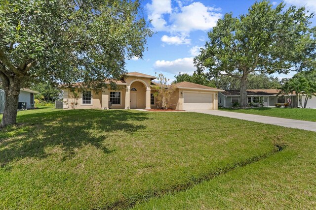 view of front of property with a front yard and a garage