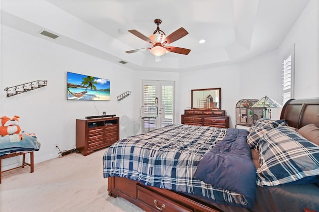 bedroom featuring ceiling fan, light carpet, and a raised ceiling