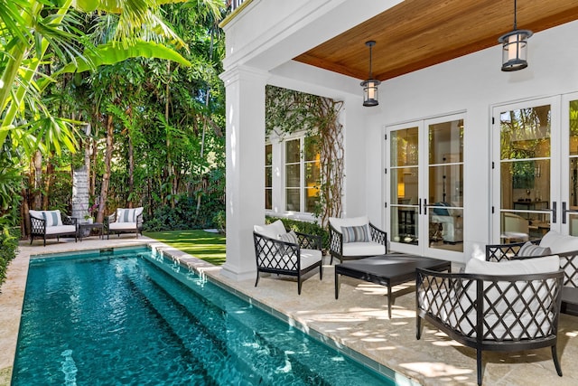 view of swimming pool featuring outdoor lounge area, french doors, and a patio