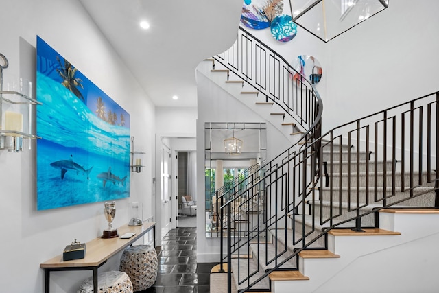 staircase with an inviting chandelier