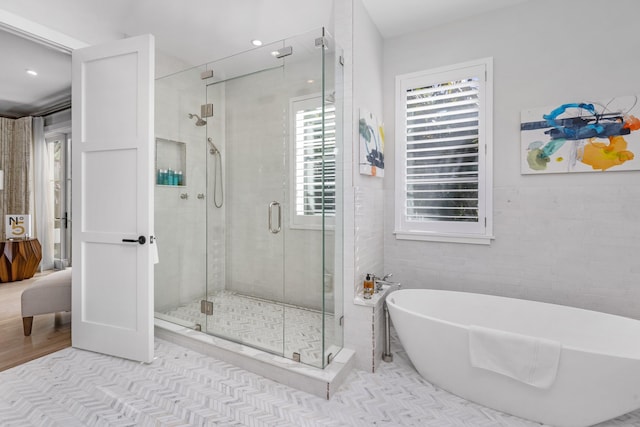 bathroom featuring tile patterned floors, tile walls, and independent shower and bath